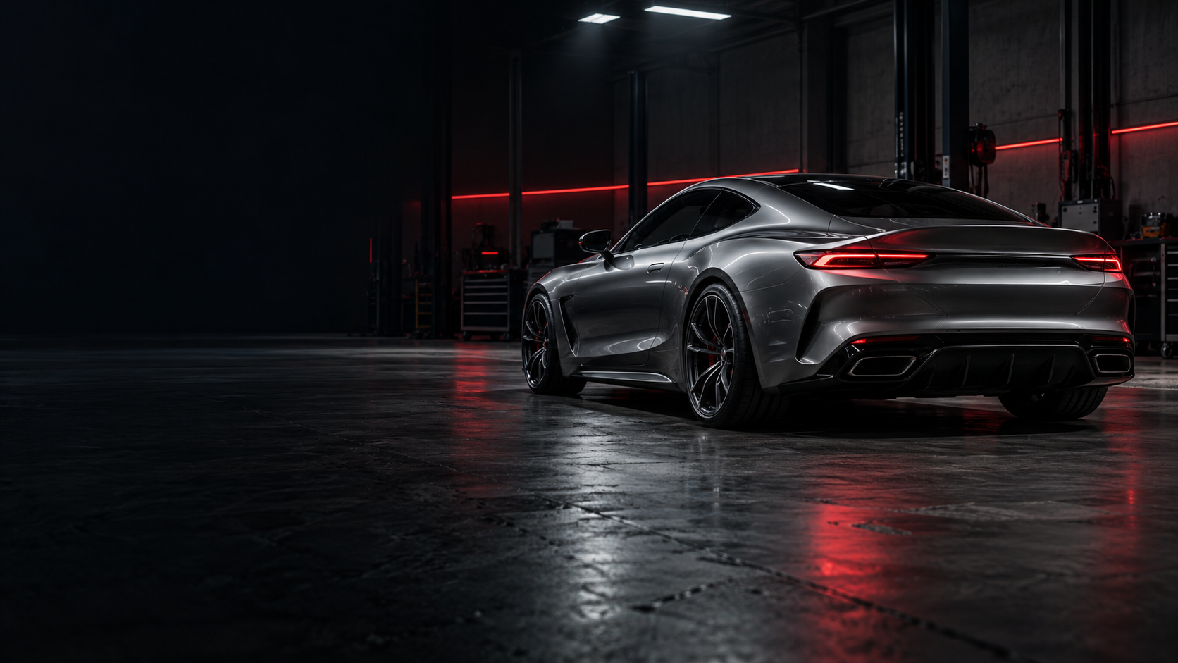 Graphite sports coupe in a dark automotive workshop, illuminated by red accent lighting